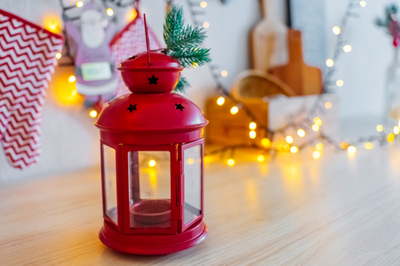 red candle light with glass walls. Christmas decoration of bokeh garland. kitchen new year 2019.の写真素材