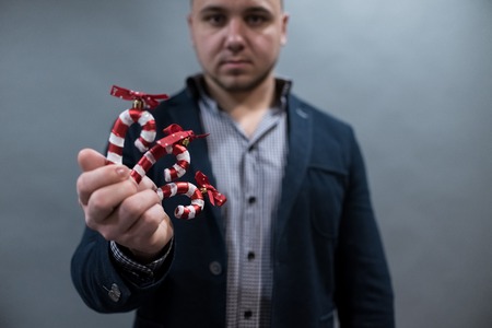 the man is holding a Christmas toy candy cane, new year 2019