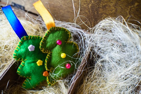 tree of felt in a wooden box with straw, new year.の写真素材