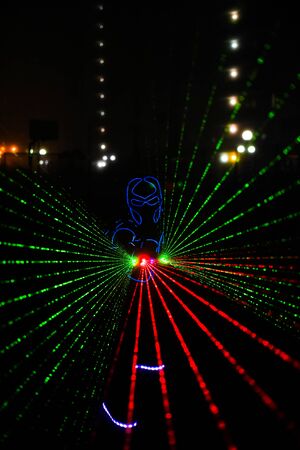 multi-colored laser beams. man laserboy. laser lines in the darkの写真素材