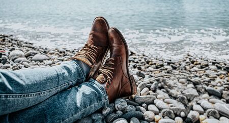 the freelancer traveler is cross legged tired at the end of the journey to the sea a pebbly beachの写真素材