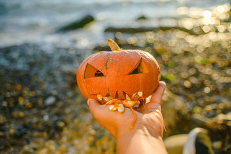orange pumpkin head for Halloween in hand. scary head Jackの写真素材