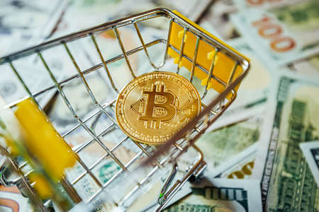 Bitcoin vs Dollars Shopping Cart Background of Hundreds of Dollars Green Yellowの写真素材