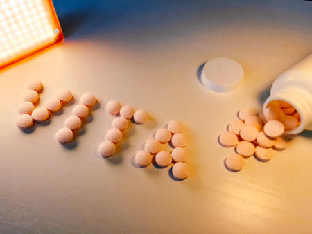 Vitamins inscription, medicine concept. Below are pills, vitamins and health capsules. calciumの写真素材
