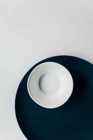 minimalism. set of dark blue large plate and white small bowl on a white background. restaurant concept. banner flatlayの写真素材