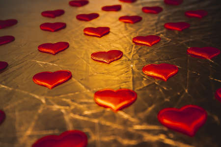 gold red background with hearts. symbol of love. Saturated abstract texture for Valentine's Day.の写真素材