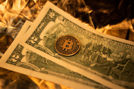 gold coin embodying the virtual cryptocurrency bitcoin a golden background. the concept of replacing the value of cash with bitcoin. retro styleの写真素材