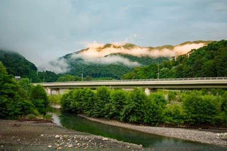 mountains after rain in the clouds. river bridge.の写真素材