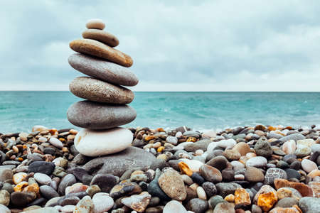 Pyramid stones balanced on the beach. The object is in focus, the background is blurredの写真素材
