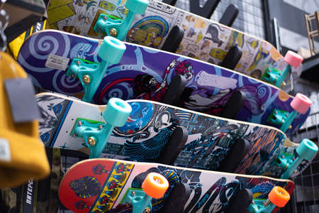 Many surfskate hanging on the skateboard shop wall. many vibrant colors.