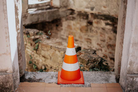 warning signal cone with a destroyed building.の写真素材