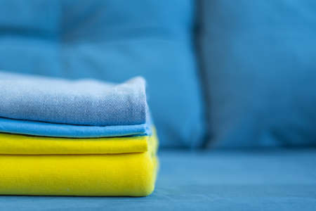 clothes of bright colors are neatly stacked. yellow blue colors of the Ukrainian flag.の写真素材