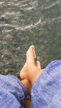 legs of the foot are suspended over the water. holiday season. Seaの写真素材