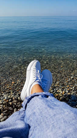 legs of the foot are suspended over the water. holiday season. Seaの写真素材
