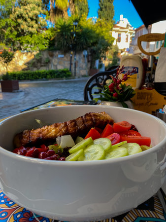 Fresh salad with tomatoes, cheese and greens on the table of street cafe. Healthy food conceptの写真素材