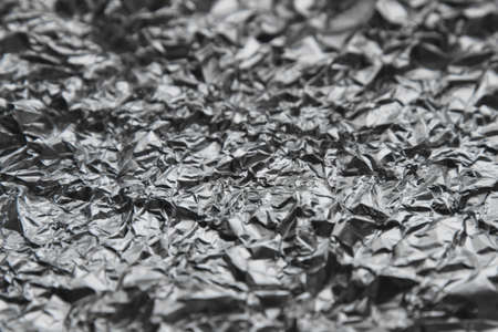 crumpled aluminum or iron foil textural macro photo for backgroundの写真素材