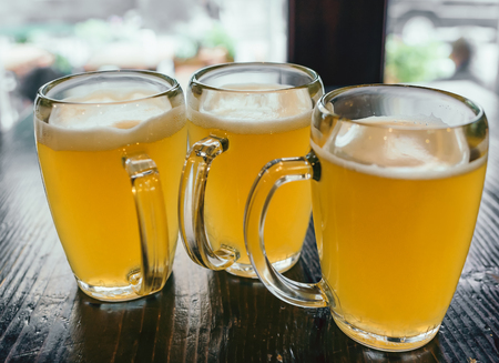 Tree cups of beer on the wooden table in the pubの写真素材