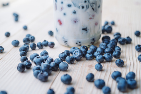 Rustic healthy breakfast with blueberry and yogurt in a glass on a wooden table. Glass of homemade yogurt with ripe berries. Healthy breakfast with vital vitamins.の写真素材