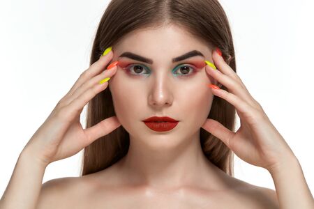 Closeup portrait of beautiful young woman with bright color make-up holding hands with bright ...
