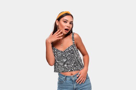 Beautiful african-american teenager in a tee and blue jeans is excited isolated over white...