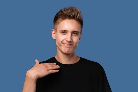 Handsome young man in a black t-shirt showing with hands that he is fed up and whant to stop it. It...