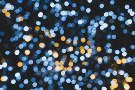 Christmas lights. Festive New Year blurred blue, golden and black background. Beautiful sparkling backdrop, texture. Bokeh. Copy space. Place for text. Template. Trendy shades. Xmas.の写真素材