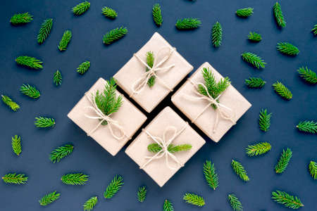 Christmas zero waste concept. Craft gifts and fir twigs on dark blue background. No plastic, new...