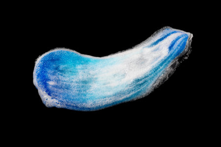 Beautiful blue smear of shaving foam on a black background isolated. Mens hygiene, skin care. Gel is...