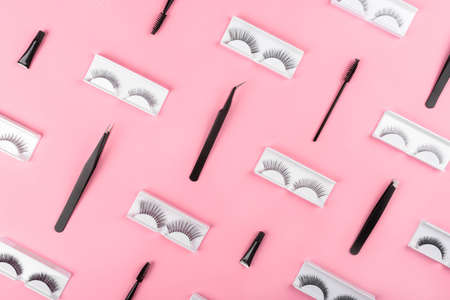 Various tools for eye lash extensions on a trendy pastel pink background. Concept. Fake eyelashes,...