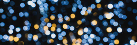 Christmas lights. Festive New Year blurred blue, golden and black background. Beautiful sparkling backdrop, texture. Bokeh. Copy space. Place for text. Template. Trendy shades. Xmas.の写真素材