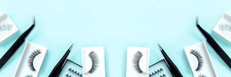 Different tools for eye lash extension on trendy pastel mint blue background. Fake eyelashes and tweezers. Beauty concept. Makeup cosmetics. Top view, flat lay. Layout. Place for text. Banner.の写真素材