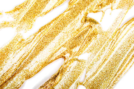 Cosmetic products. Makeup texture. Golden smudged texture of paint, gold face mask, nail polish on...