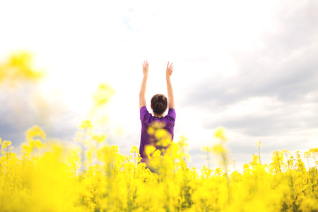 Young girl on a background of yellow field flowers. Beautiful stylish romantic. Colza, rapeseed,...