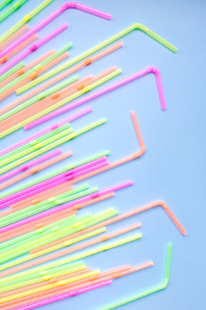 Colorful plastic straws on blue background. Cocktail tubes. Place for your text. Say no plastics. Plastic free concept.の写真素材