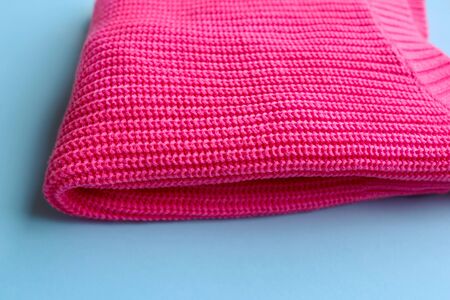 Plastic pink jacket isolated on blue background. Copy space for your text. Flat lay, top view. Color...