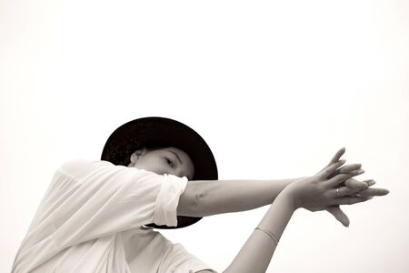 Fashion girl with a black hat. Beautiful young model. Contrast photo.