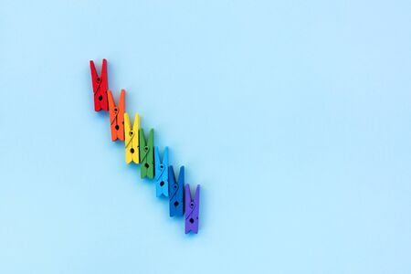 Many colored clothespins on a blue background. School concept. Minimalism.の写真素材
