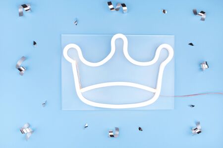 Glowing neon crown on blue background with confetti. Neon concept. Modern style. Neon sign.の写真素材