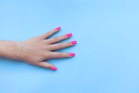 Stylish trendy female manicure. Beautiful neon plastic pink nails on blue background.の写真素材