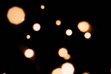 Golden abstract bokeh sparkle on black isolated background. Holiday concept. Place for design. Festive concept.の写真素材