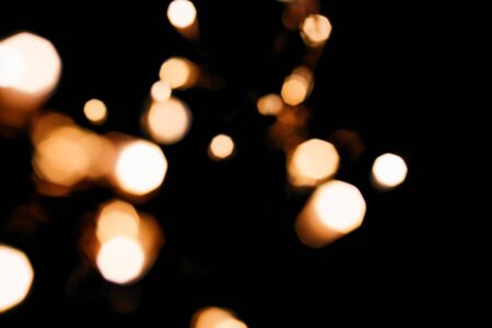 Golden abstract bokeh sparkle on black isolated background. Holiday concept. Place for design. Festive concept.の写真素材