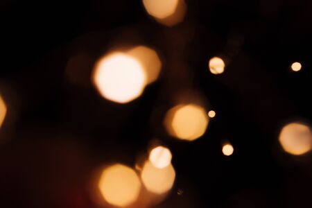 Golden abstract bokeh sparkle on black isolated background. Holiday concept. Place for design. Festive concept.の写真素材