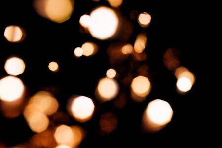 Golden abstract bokeh sparkle on black isolated background. Holiday concept. Place for design. Festive concept.の写真素材