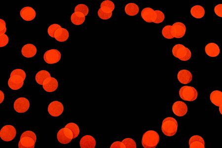 Halloween holiday background with orange confetti on an isolated black background. Flat lay style. Top view. Pattern with confetti.の写真素材