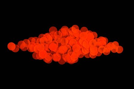 Halloween holiday background with orange confetti on an isolated black background. Flat lay style. Top view. Pattern with confetti.の写真素材