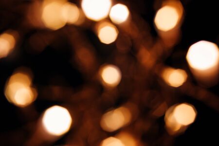 Golden abstract bokeh sparkle on black isolated background. Holiday concept. Place for design. Festive concept.の写真素材