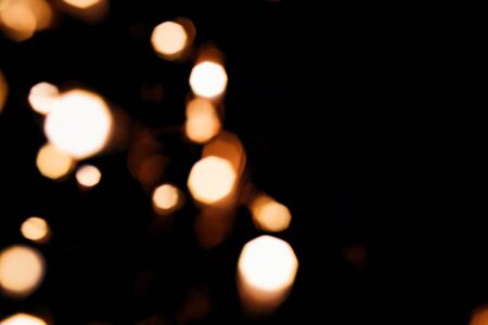 Golden abstract bokeh sparkle on black isolated background. Holiday concept. Place for design. Festive concept.の写真素材