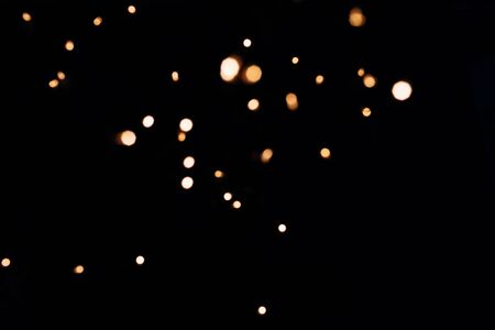 Golden abstract bokeh sparkle on black isolated background. Holiday concept. Place for design. Festive concept.の写真素材