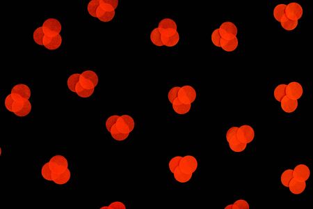 Halloween holiday background with orange confetti on an isolated black background. Flat lay style. Top view. Pattern with confetti.の写真素材