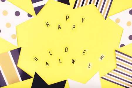 Happy Halloween letters on a yellow background with garland flags. Holidays, decoration and party concept. Flat lay, copy space, top view. Happy Halloween Card.の写真素材